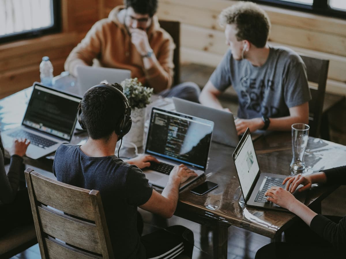 A small team working together on laptops around a shared table